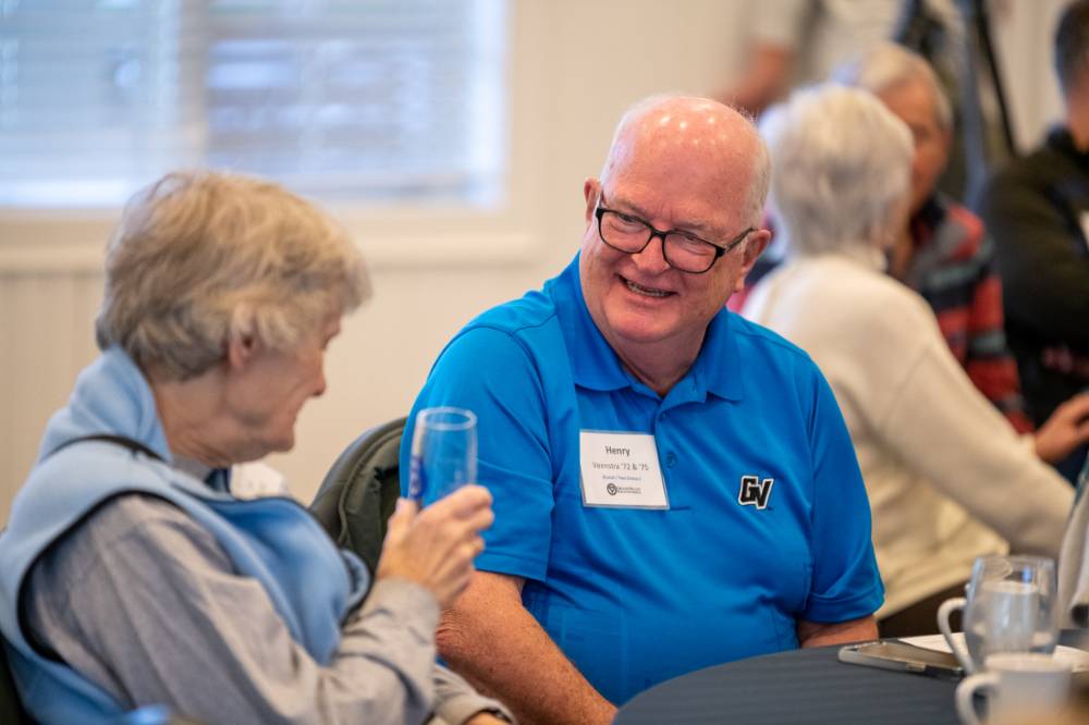 Two alumni laughing together.